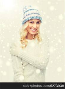 winter, fashion, christmas and people concept - smiling young woman in winter hat, sweater and gloves. smiling young woman in winter hat and sweater