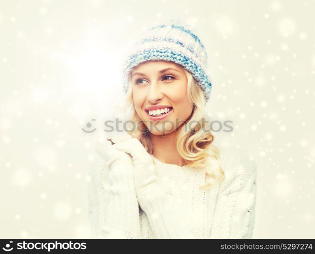 winter, fashion, christmas and people concept - smiling young woman in winter hat, sweater and gloves. smiling young woman in winter hat and sweater