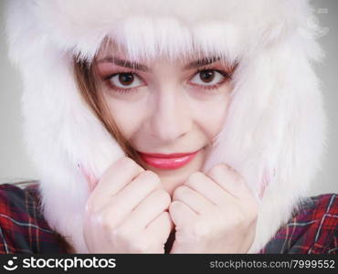 Winter fashion. Close up young woman wearing fashionable wintertime clothes white fur cap studio shot on gray background