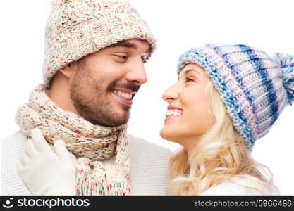winter, fashion, couple, christmas and people concept - smiling man and woman in hats and scarf hugging