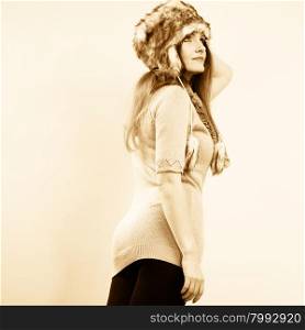 Winter fashion. Happy young woman wearing fashionable wintertime clothes fur cap portrait