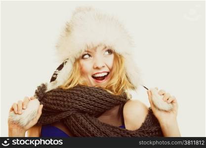 Winter fashion. Portrait positive teen girl in warm clothes. Happy young woman in fur hat doing fun on gray.