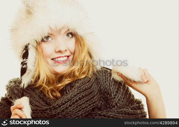 Winter fashion. Portrait positive teen girl in warm clothes. Happy young woman in fur hat doing fun on gray.