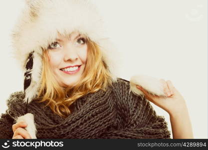 Winter fashion. Portrait positive teen girl in warm clothes. Happy young woman in fur hat doing fun on gray.