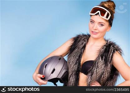 Winter, fashion, sport concept. Beautiful girl with goggle and helmet. Lady is wearing fur and bra.. Lady is wearing fur and bra.