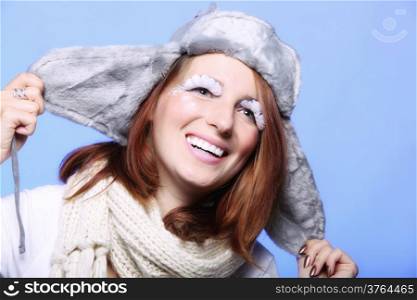winter fashion woman in warm clothing fur hat stylish creative make up false long white eye lashes blue background