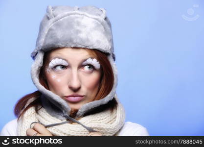 winter fashion woman in warm clothing fur hat stylish creative make up false long white eye lashes blue background