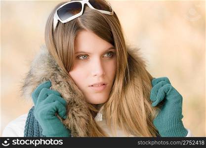 Winter fashion - woman with fur hood and gloves outside, desaturated colors