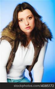 Winter fashion. Young woman plus size model posing in warm waistcoat studio shot on blue