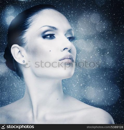 Winter freshness, abstract female portrait with falling snow as background