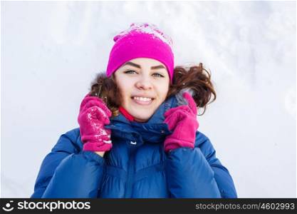 Winter fun. Happy young woman lying on snow in winter forest