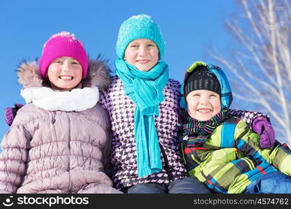 Winter fun. Three children enjoying sledge ride in beautiful snowy winter park