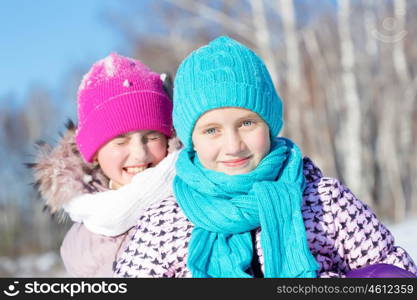 Winter fun. Two cute girls enjoying sledge ride in beautiful snowy winter park