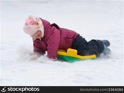 Winter games children - a girl sledding down the hills