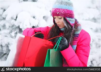 winter girl with gift bags on snow background