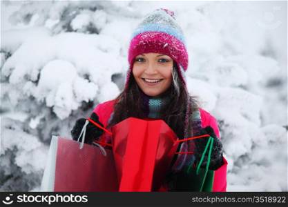 winter girl with gift bags on snow background
