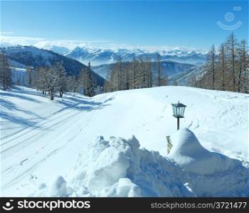 Winter hazy view from Dachstein mountain massif (Austria) and lamp near hotel entrance