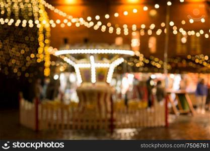 winter holidays and celebration concept - blurred christmas market in evening at town hall square in tallinn, estonia. christmas market at tallinn old town hall square