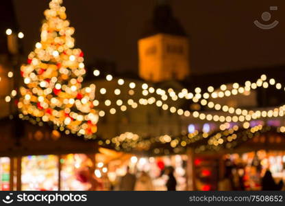 winter holidays and celebration concept - blurred christmas market in evening at town hall square in tallinn, estonia. christmas market at tallinn old town hall square