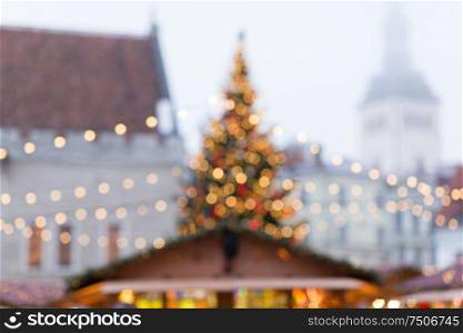 winter holidays and celebration concept - blurred christmas market in winter evening at town hall square in tallinn, estonia. christmas market at tallinn old town hall square