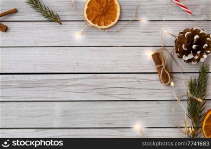 winter holidays and celebration concept - close up of garland lights and christmas decorations on wooden boards background. garland lights and christmas decorations