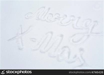 winter holidays and christmas concept - merry x-mas words on snow surface. merry christmas words on snow surface