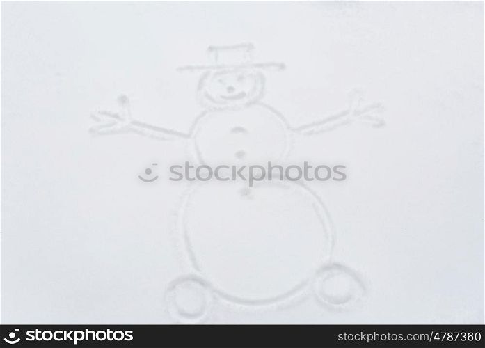 winter holidays and christmas concept - snowman drawing on snow surface. snowman drawing on snow surface