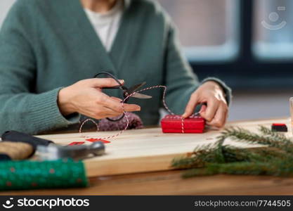 winter holidays and hobby concept - close up of woman with box, rope and scissors packing christmas gift or making advent calendar at home. close up of woman packing christmas gift at home