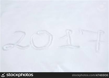 winter holidays and new year concept - calendar number 2017 or date on snow surface. new year 2017 number or date on snow surface
