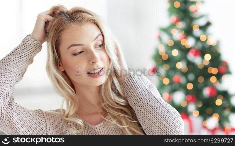 winter, holidays and people concept - happy young woman or teenage girl at home over christmas tree background. happy young woman or teenage girl at christmas
