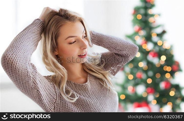 winter, holidays and people concept - happy young woman or teenage girl at home over christmas tree background. happy young woman or teenage girl at christmas
