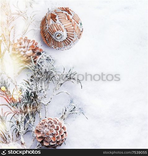 Winter holidays background with fir branches with vintage Christmas bauble and cones on snow with bokeh lighting. Copy space