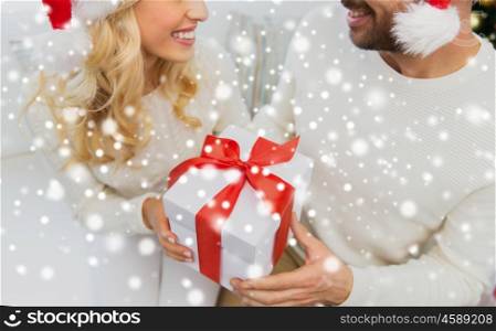 winter, holidays, christmas and people concept - close up of happy couple with christmas gift at home