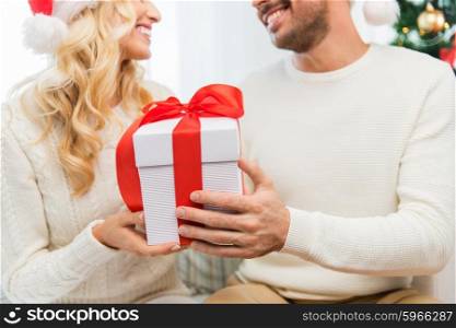 winter, holidays, christmas and people concept - close up of happy couple with christmas gift at home