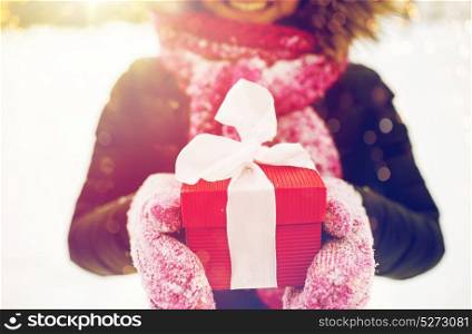 winter holidays, christmas and people concept - close up of happy woman with present or gift box outdoors. close up of woman with christmas gift outdoors