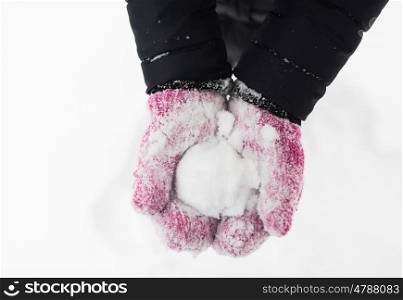 winter holidays, christmas and people concept - close up of woman holding snowball outdoors