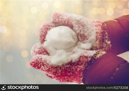 winter holidays, christmas and people concept - close up of woman holding snowball outdoors. close up of woman holding snowball outdoors