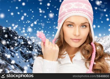 winter holidays, christmas, fashion and people concept - happy young woman in winter hat over snow and mountains background