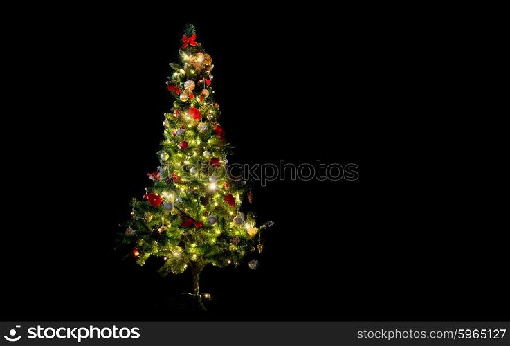 winter, holidays, decoration and illumination concept - beautiful decorated and illuminated christmas tree over black background