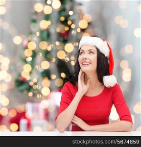 winter, holidays, happiness and people concept - smiling woman in santa helper hat over christmas tree lights background