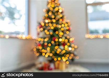 winter holidays, new year and celebration concept - blurred christmas tree lights at home. blurred christmas tree lights at home