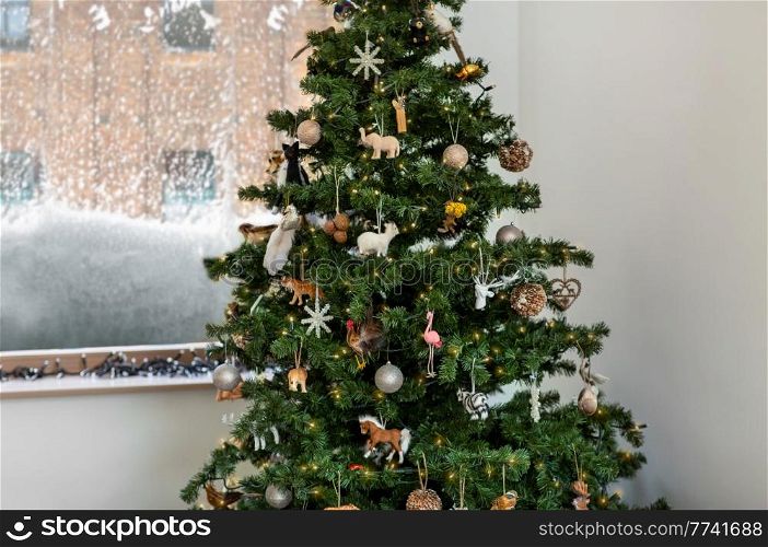 winter holidays, new year and celebration concept - green artificial christmas tree decorated with vintage toys at home. decorated artificial christmas tree at home