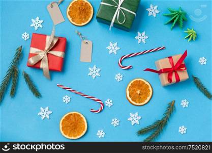 winter holidays, new year and christmas concept - gift boxes, fir tree branches, tags and decorations on blue background. christmas gifts, tags and decorations
