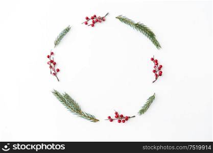 winter holidays, new year and decorations concept - frame of fir branches with red berries on white background. christmas frame of fir branches with red berries