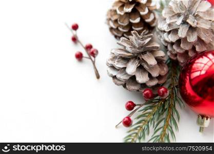 winter holidays, new year and decorations concept - red christmas balls and fir branches with pine cones on white background. christmas balls and fir branches with pine cones