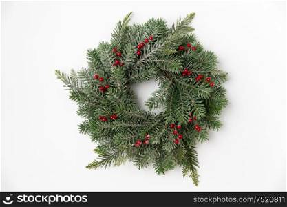 winter holidays, new year and decorations concept - wreath of fir branches with red berries on white background. christmas wreath of fir branches with red berries