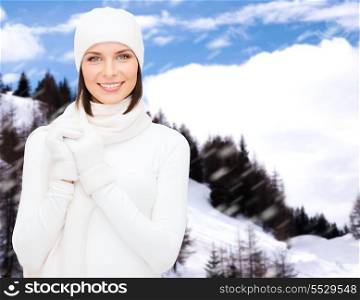 winter holidays, vacation, people and happiness concept - woman in hat, muffler and gloves