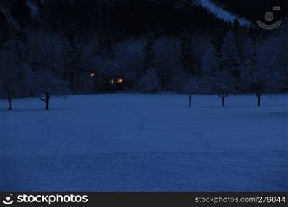 Winter landscape and a house with lights