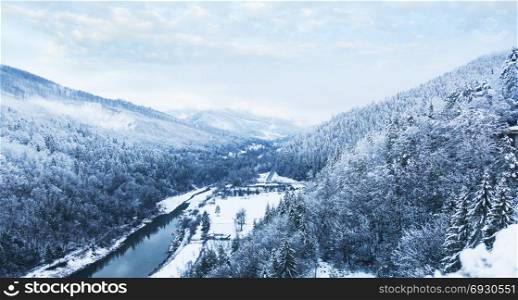 Winter landscape. Forest and river in the mountains.