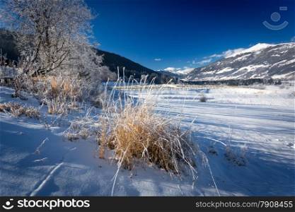 Winter landscape of highland valley covered by snow in Alps at sunny day